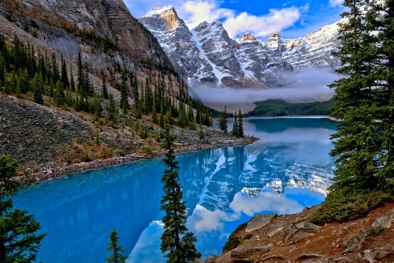 Turquoise glacial lake below the snow-dusted peaks of the Canadian Rockies