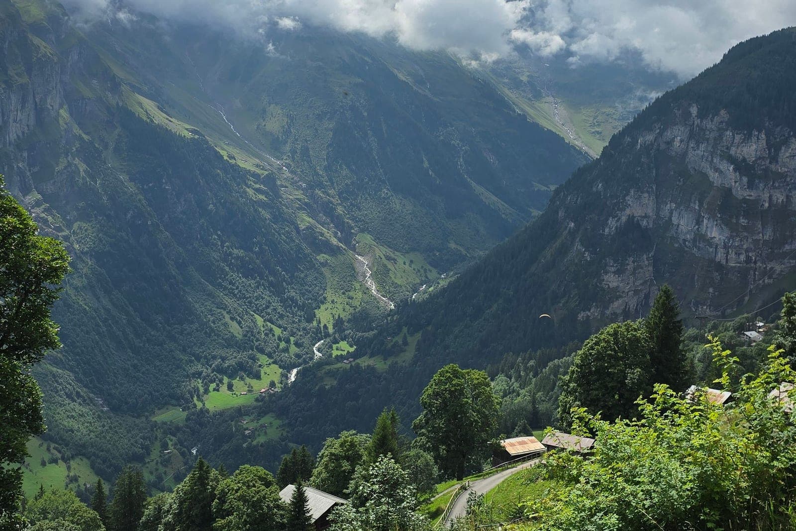 The Lauterbrunnen valley seen from above, chalets on the slope and cliffs falling to the river